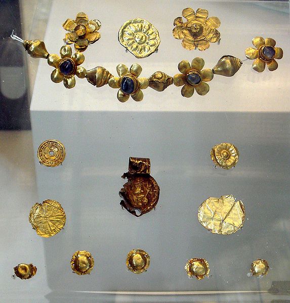 Offerings found in Bodh Gaya under the "Enlightenment Throne of the Buddha", with a decorated coin of the Kushan emperor Huvishka, 3rd century AD. British Museum.