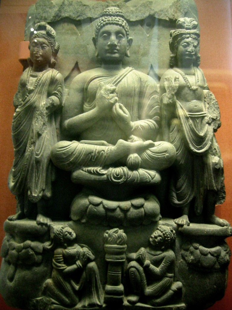 Buddha triad and kneeling Kushan devotee couple. 3rd century